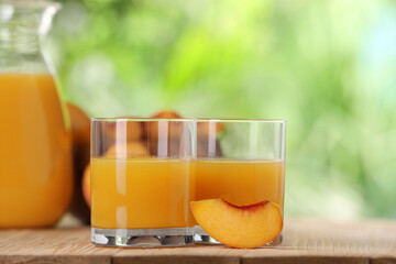 Tasty peach juice and fresh fruit on wooden table outdoors, closeup