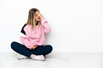 Young woman sitting on the floor at indoors laughing