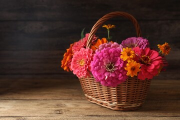 Fototapeta na wymiar Beautiful wild flowers in wicker basket on wooden table. Space for text
