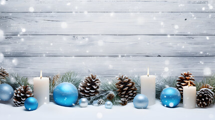 Blue Christmas candles, balls and pine cones in a row with spruce branches covered with snow and...
