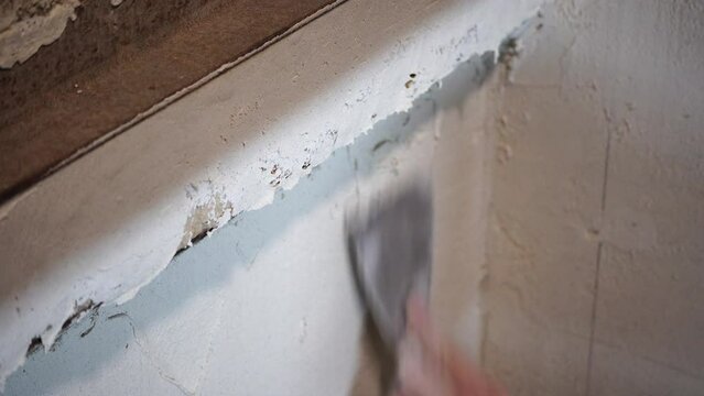 Male builder use metal spatula for putty walls, repairman filling spatula with spackling paste and covering cement wall surface. Builder leveling wall and angle Renovation work in Residential Premises