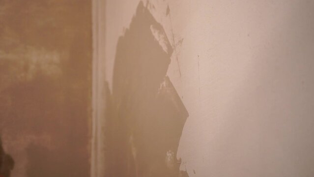 Male builder use metal spatula for putty walls, repairman filling spatula with spackling paste and covering cement wall surface. Builder leveling wall and angle Renovation work in Residential Premises