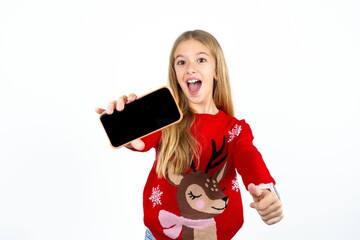 Naklejka premium Portrait Beautiful girl wearing red knitted sweater holding in hands cell showing giving black screen thumb up