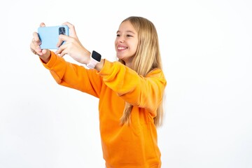 Beautiful teen blonde girl  taking a selfie to post it on social media or having a video call with...