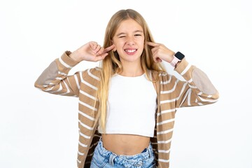 Happy Beautiful teen girl ignores loud music and plugs ears with fingers asks to turn off sound