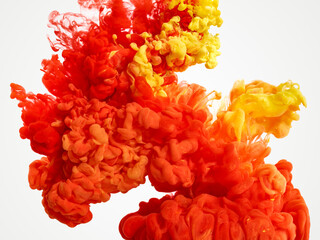 Blended red and yellow paint pigments in water on white background