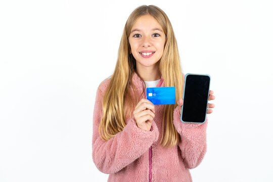 Photo of adorable Beautifu blonde kid girl  holding credit card and Smartphone. Reserved for online purchases