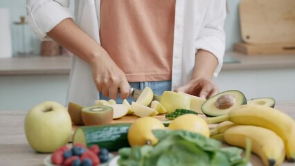 Video of beauty woman cutting pepino to prepare a detox juice in the kitchen at home