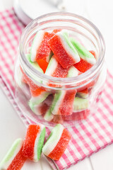 Watermelon jelly candies  in jar on kitchen table.