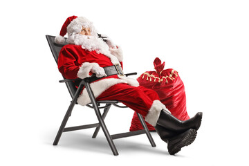 Santa claus sitting in a foldable chair and making a phone call
