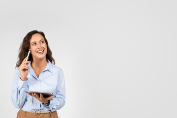 Pensive smiling european young woman professional use tablet, think with pencil, look at free space