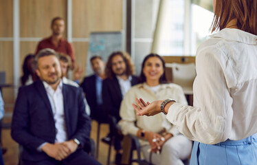 Woman standing back speaking on a business training in office during a conference or seminar for a...