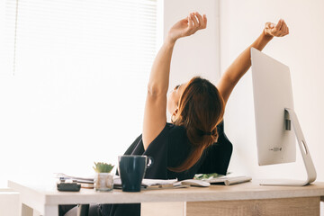 Rear view of Asian business woman stretching and relaxing from work - Powered by Adobe