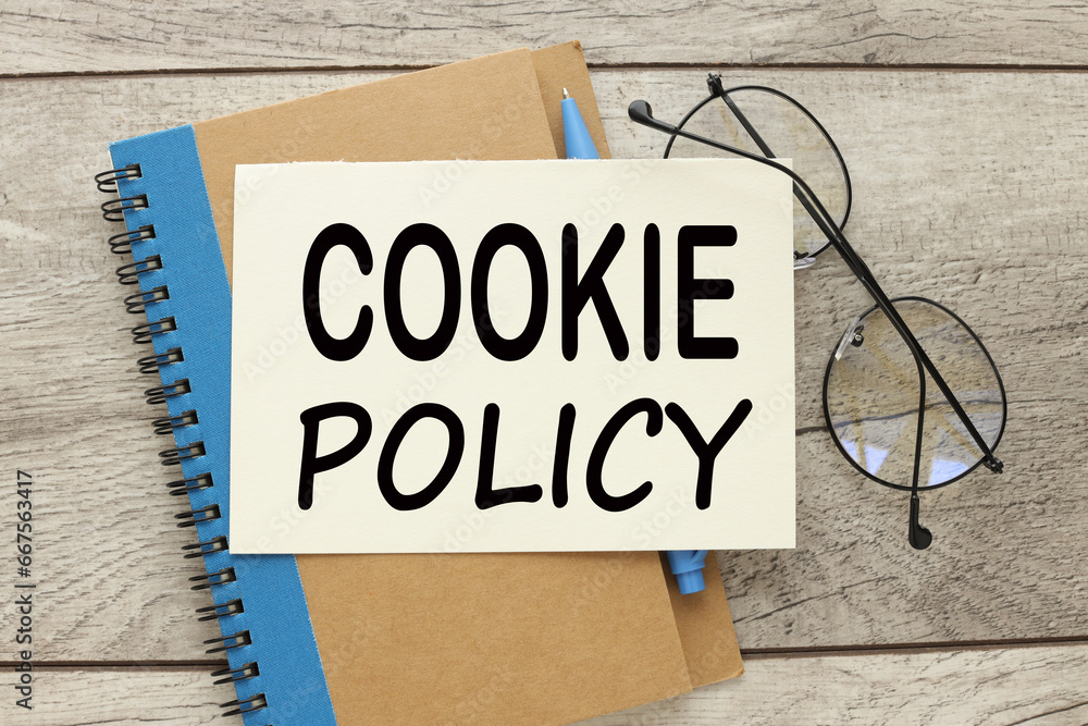 Poster cookie policy notebook with a blue stripe and glasses on the notebook.