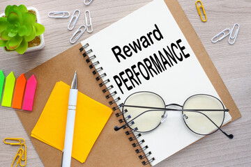 REWARD PERFORMANCE open notebook with stickers and plants in a pot. word on page