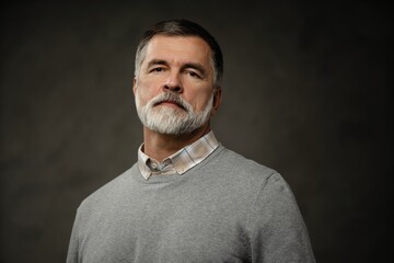 Portrait of happy casual mature man smiling, senior age man with gray hair, Isolated on dark gray background