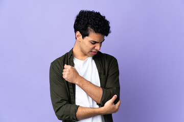 Obraz premium Young Venezuelan man isolated on purple background with pain in elbow