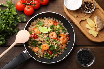 Tasty rice with shrimps and vegetables served on wooden table, flat lay