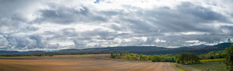 ciel très nuageux, vue panoramique sur des champs en Auvergne Rhône Alpes