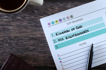 Christian top priorities list, seek first kingdom of God and His righteousness, handwritten text in notebook with cup of coffee and holy bible book on wooden table. Biblical concept. - obrazy, fototapety, plakaty