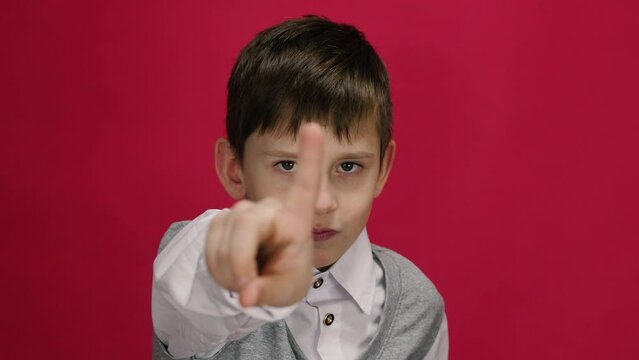 A schoolboy shows "no" with a hand gesture. Disagreement and mistrust. Concept of transferring information by gestures.