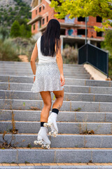 Middle age skater woman roller skating climbing stairs.