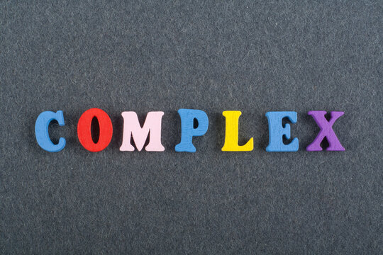 COMPLEX word on black board background composed from colorful abc alphabet block wooden letters, copy space for ad text. Learning english concept.
