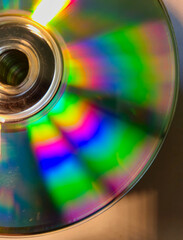 Close-up to interesting abstract patterns created by the rays of sunlight reflecting from the surface of the CD lying on the desk, Lodz, Poland.