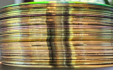 Close-up to interesting abstract patterns created by the rays of sunlight penetrating through a pile of CD arranged on the desk, Lodz, Poland.
