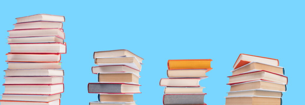 Composition with hardback books on wooden deck table and blue background. Books stacking. Back to school. Copy Space. Education background. panorama, banner.