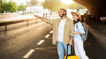 Cheerful millennial european family tourists with suitcase stop taxi, wait transport on station