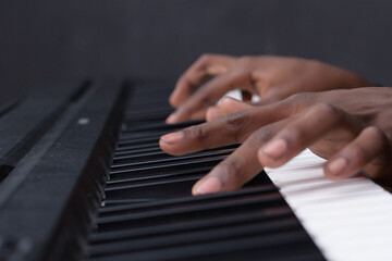 Fototapeta premium hands of a person playing piano keyboard music pianist in Kenya East Africa fingers on the Keys classical closeup player musical