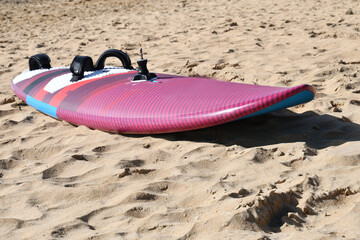 Planche à voile posée sur le sable