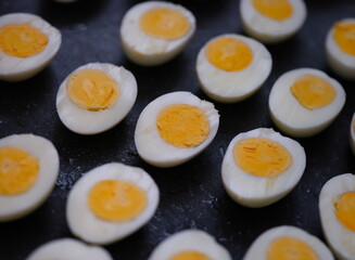 Many halves of boiled chicken eggs lying on table closeup background. Healthy eating concept