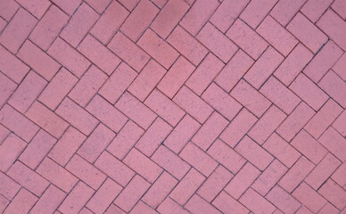 Paving slabs laid out in shape of herringbone on city street background. Improvement of streets...