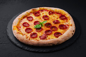 Pepperoni Pizza with Basil and Parmesan Cheese on Black Stone Plate