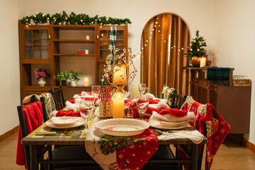 Empty traditional Christmas dinner table inside decorated living room with holiday garlands and dinnerware. Interior of traditional and authentic season cozy setting celebrating religious event.