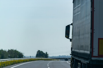 Image of a big truck on a clear curved road in open space on a sunny day with good copy space