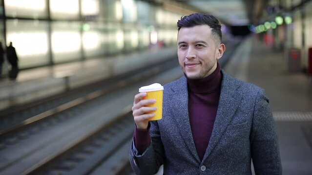 Businessman waiting for a train with hot coffee cup  