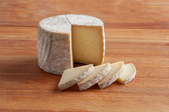 Whole Zamorano cheese, Spain. Cured cheese, old sheep's cheese cut into thin slices.