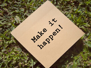 Motivational and inspirational wording. Make It Happen written on a notepad. With blurred styled background.