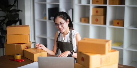 Closeup woman Asian is writing a list of customer on paper before shipping to them, she runs an ecommerce business on websites and social media