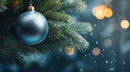 Poster Christmas tree branch with blue bauble and bokeh lights background. © Synthetica