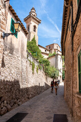 Fototapeta na wymiar Rear view of tourists exploring Valldemosa village on Majorca island, Spain