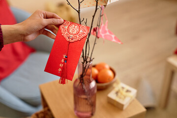 Close up of male hand holding hongbao red envelope as Chinese New Year tradition, copy space Have...