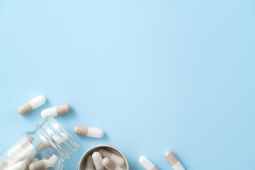 Taking medicine design concept, top view of capsule pills on blue table background.