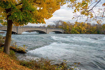 Beautiful fall foliage autumn leaves with Goat Island Bridge in Niagara Falls State Park, upstream...