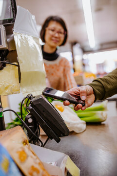 Arm of man paying by card at supermarket counter