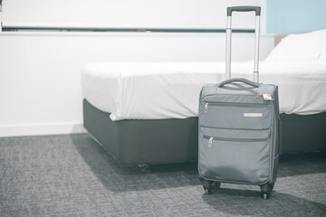 ホテルのダブルサイズのベッドルームと旅行用キャリーケース