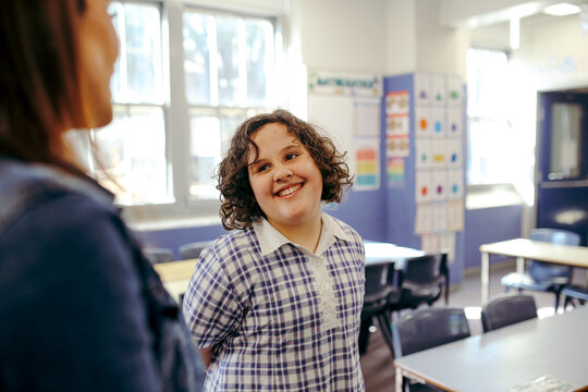 Girl primary school student with her female teacher in the classroom at school